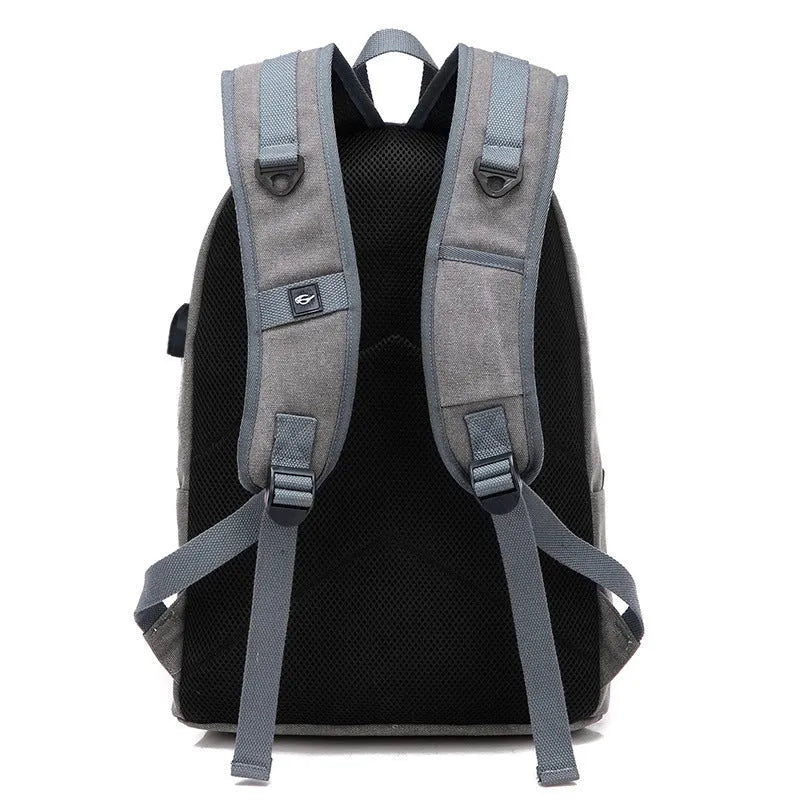 Canvas backpack with USB charging port showing computer compartment and multiple pockets