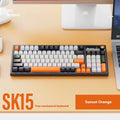 SK15 wired mechanical gaming keyboard with control knob in sunset orange colour beside notebook computer