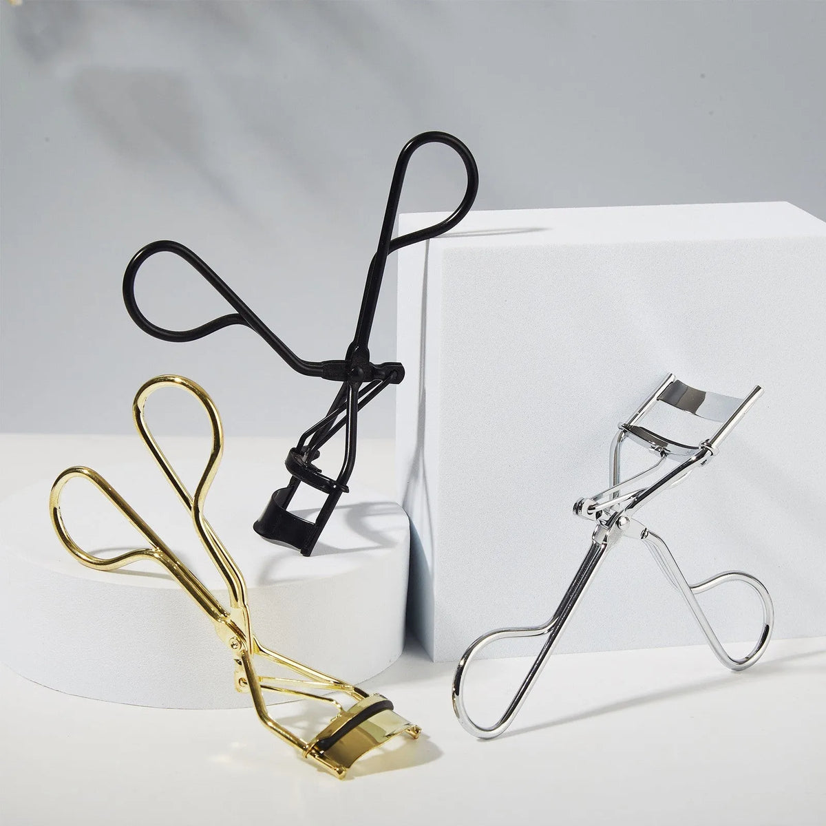 Metal eyelash curler in black on white background, non-electric integral beauty makeup tool