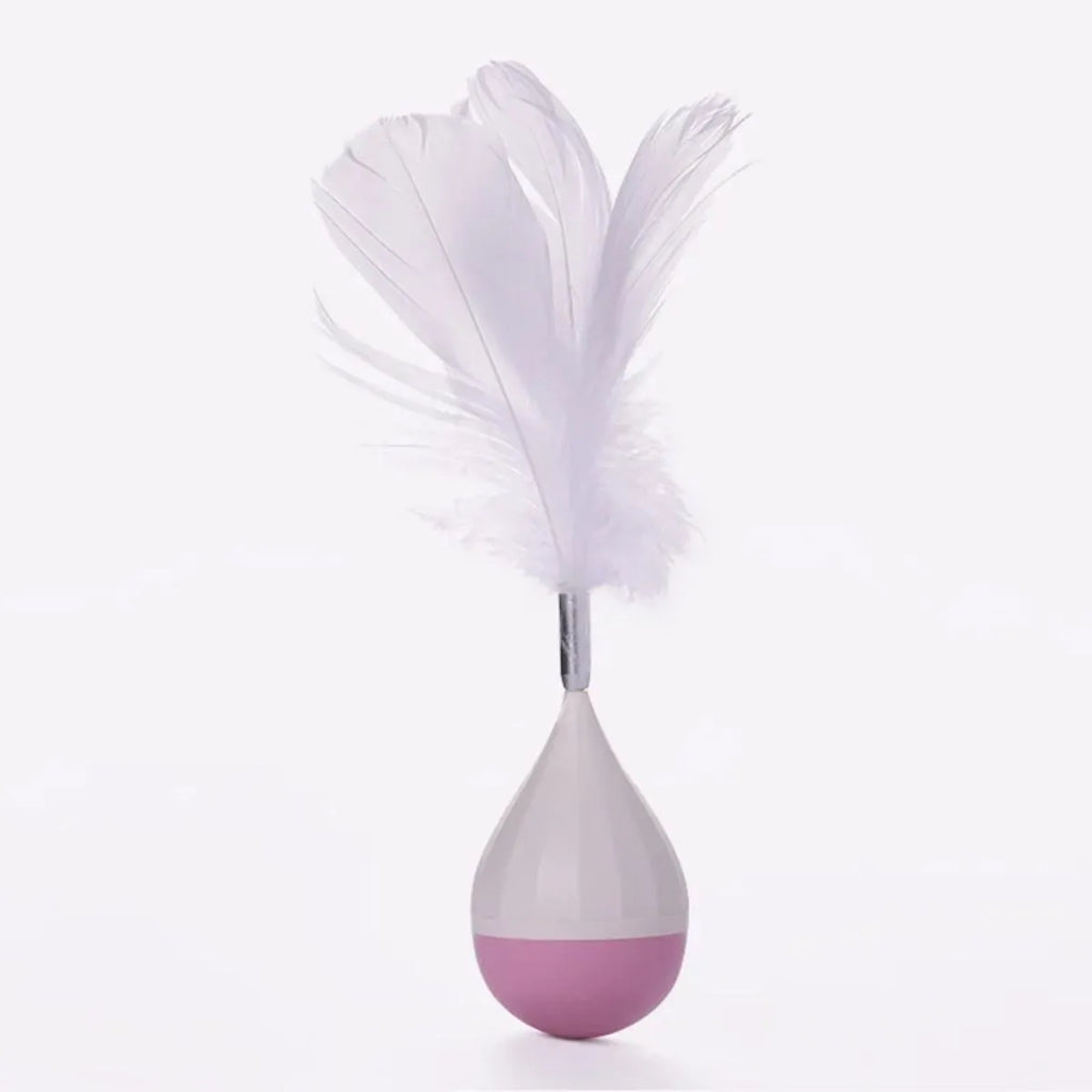 Green feather tumbler cat toy with goose feathers and aluminium alloy components on wooden floor