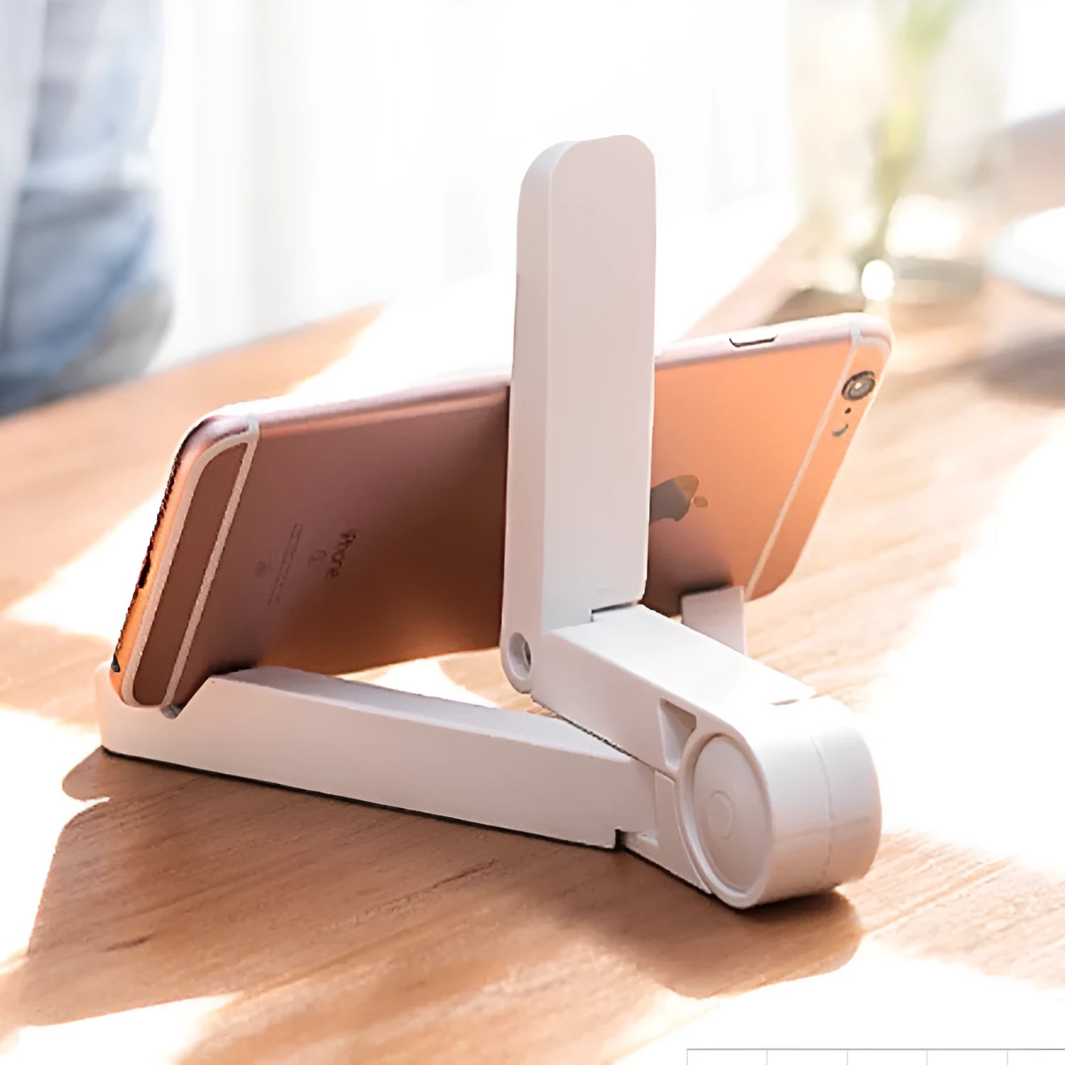 Black foldable tablet holder supporting a smartphone in landscape viewing mode on a desk.