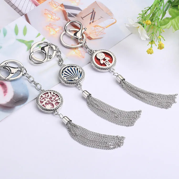 Alloy metal car fragrance pendant with tassel on a 50cm chain, shown with scented cotton pieces.