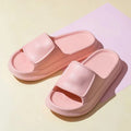 Unisex EVA flip-flop slippers with thick sole, shown in various colours on a bathroom tile floor.