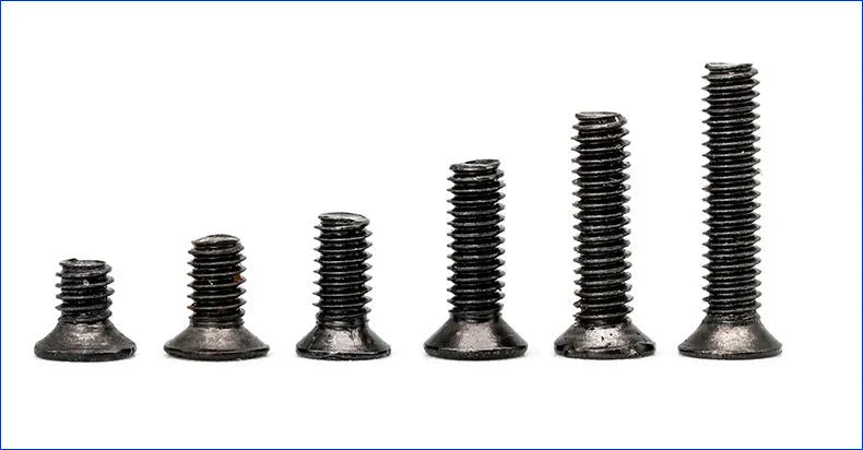 Black plated flat head laptop machine screws with Phillips drive, shown loose and in a box.