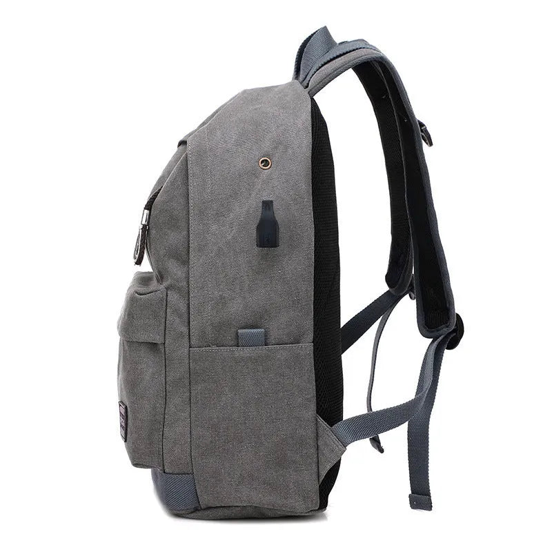 Canvas backpack with USB charging port showing computer compartment and multiple pockets