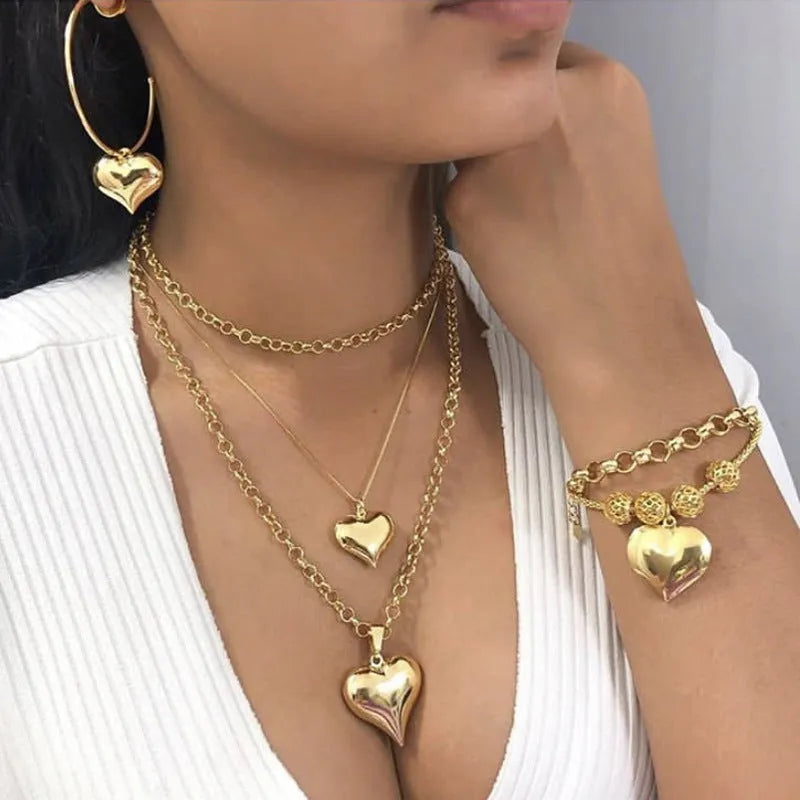 Gold multi-layer heart pendant necklace for women with alloy construction and electroplated finish.