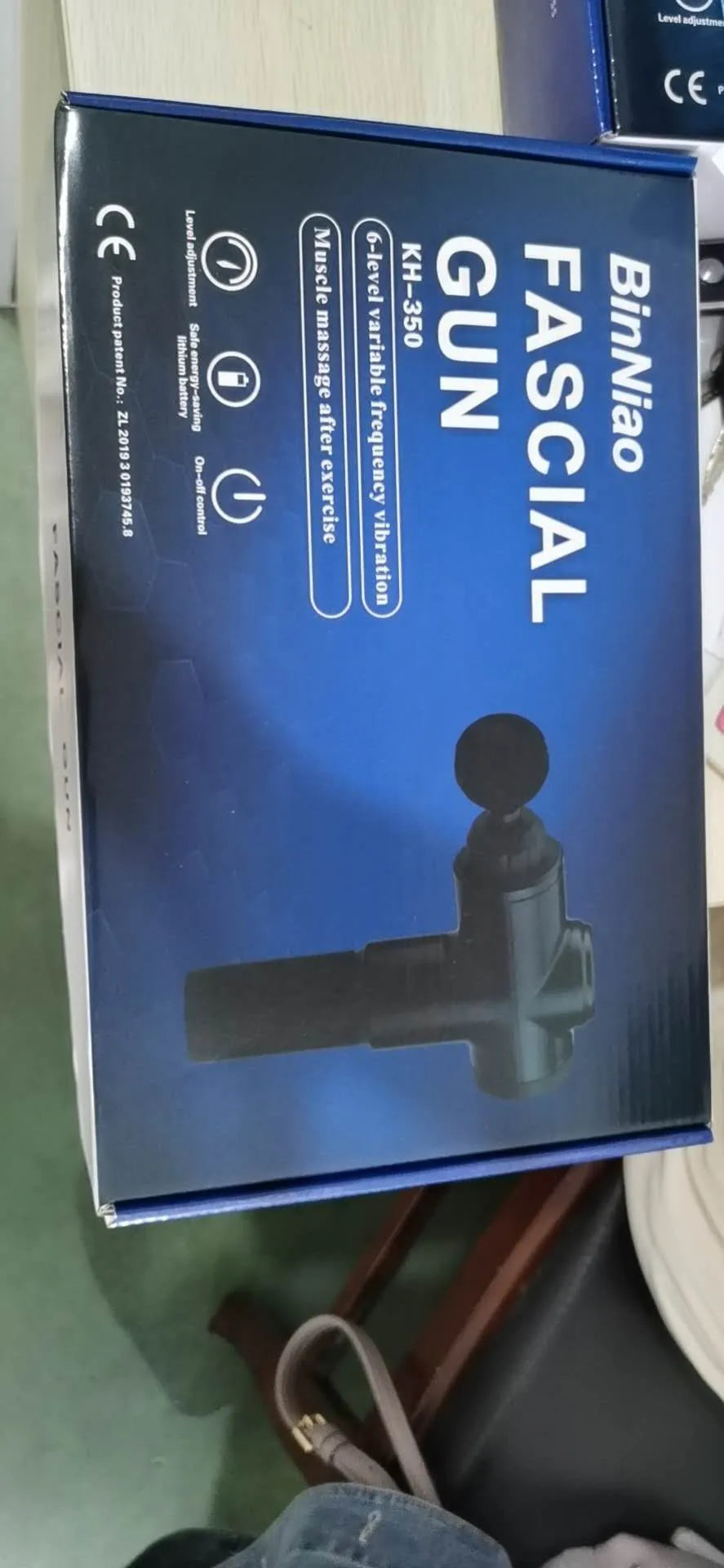 Black rechargeable percussion massage gun with 2000mAh battery and variable speed 1200-3300 rpm