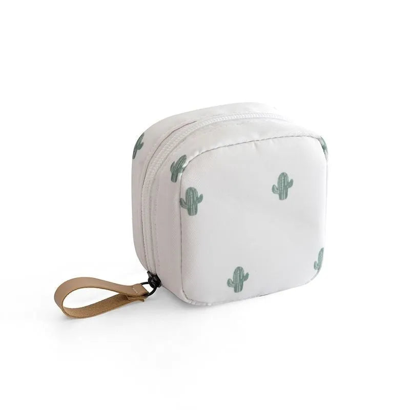 Blue cloth cube-shaped makeup bag with a zipper closure, resting on a surface.