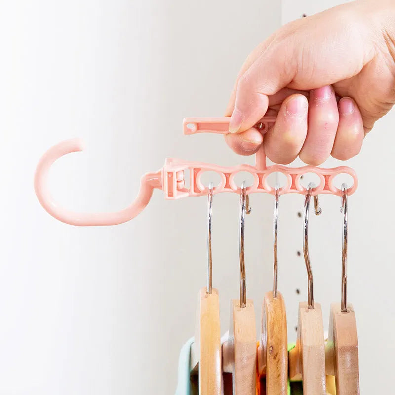 Blue revolving plastic wardrobe hanger with five arms and a top handle for rotation.