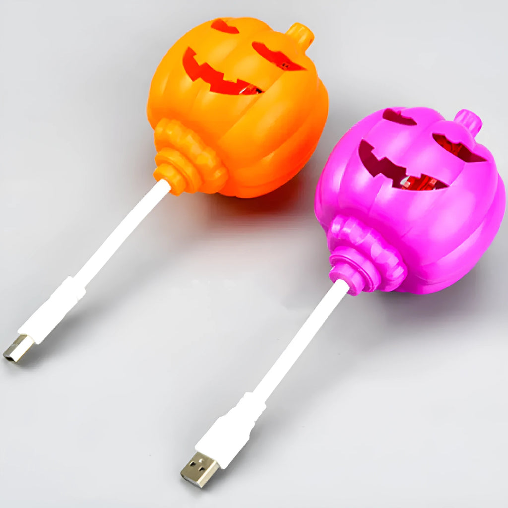 A plastic pumpkin lamp with a USB port, glowing in either yellow or purple light.