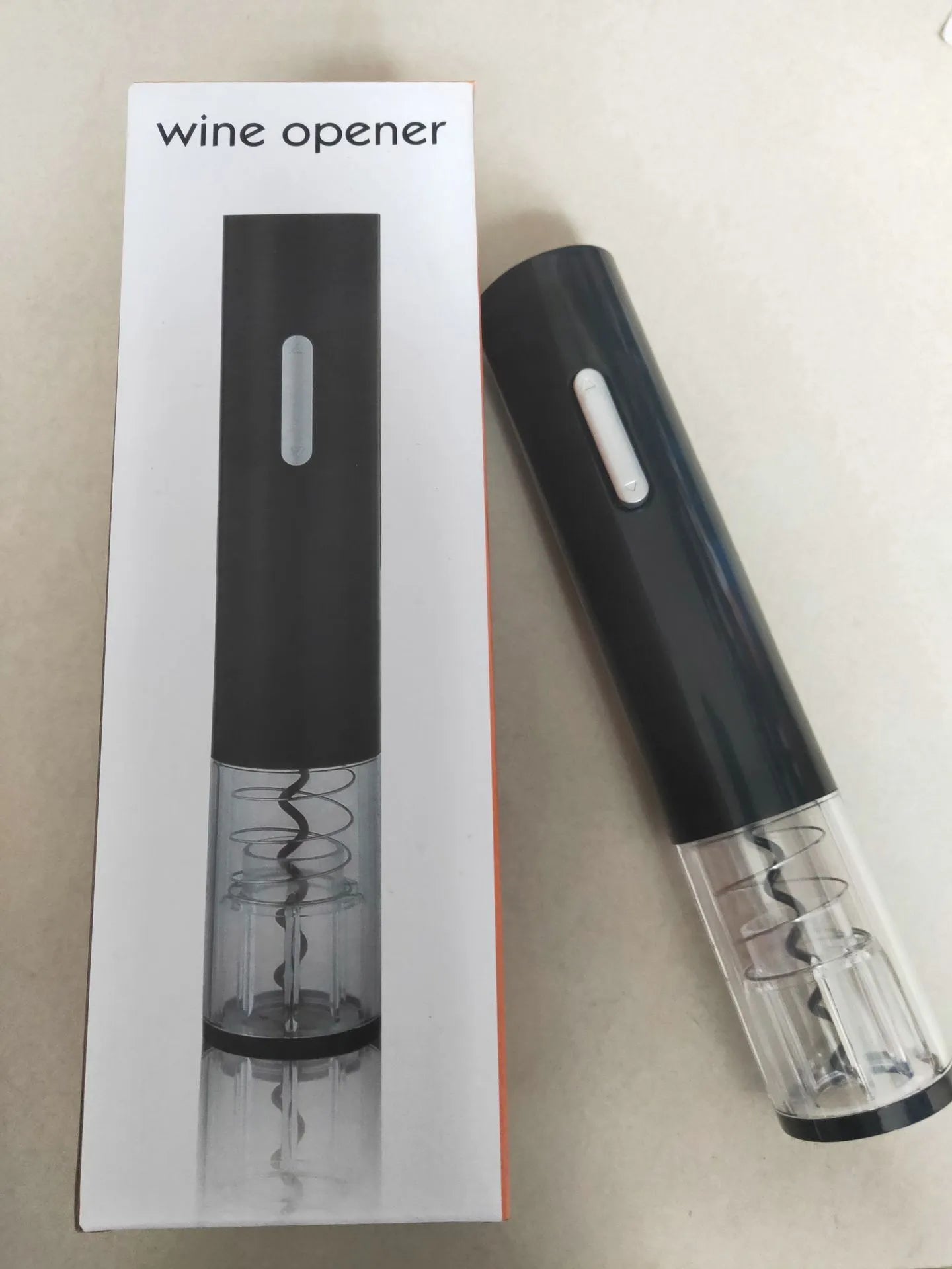 Black electric wine bottle opener with automatic corkscrew and foil cutter on a kitchen counter