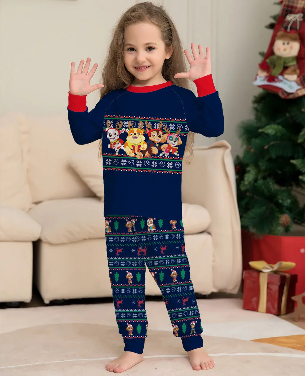 Family wearing matching red plaid Christmas pyjamas with deer print, including adults, children, and a dog.