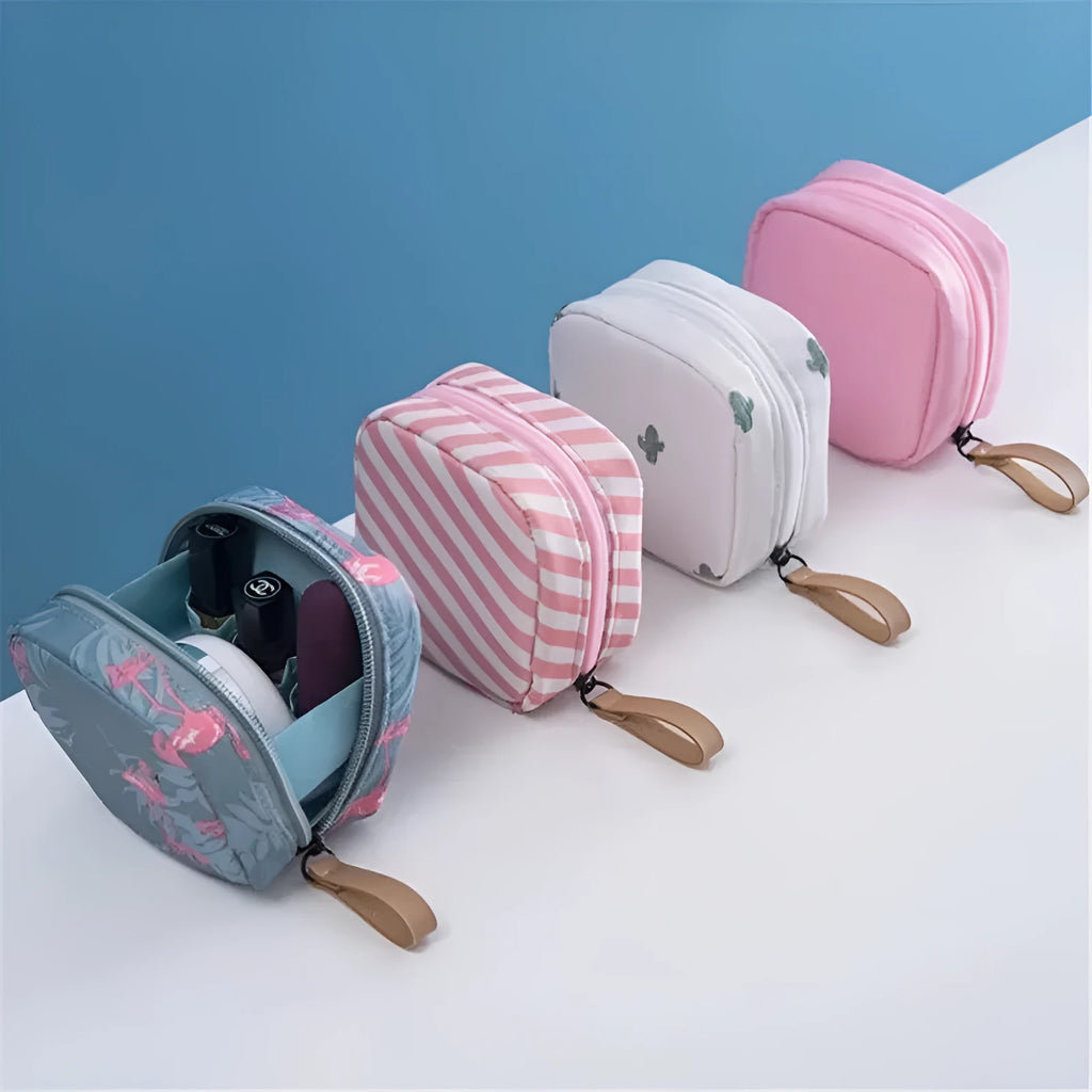 Blue cloth cube-shaped makeup bag with a zipper closure, resting on a surface.