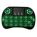 Backlit I8 mini wireless keyboard with touchpad in use on a table with smart TV in background