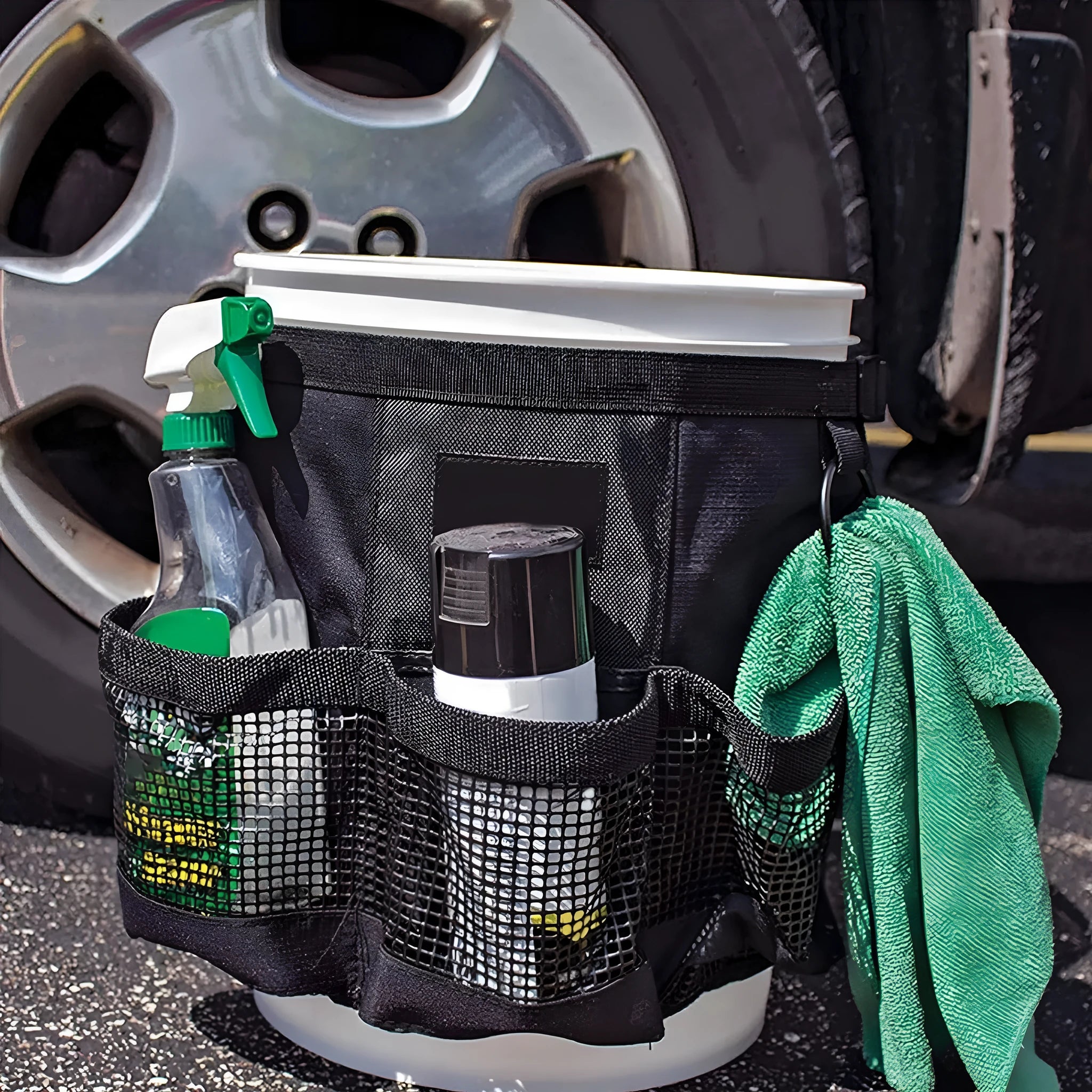 Black cylindrical buggy storage bag hanging from a 5 gallon barrel with car washing tools inside