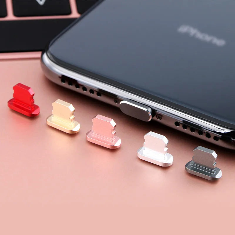 Aluminium alloy iPhone charging port dust plug in various colours including gold, silver, blue, and rose gold.
