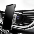Black magnetic car phone holder mounted on car air vent with phone attached