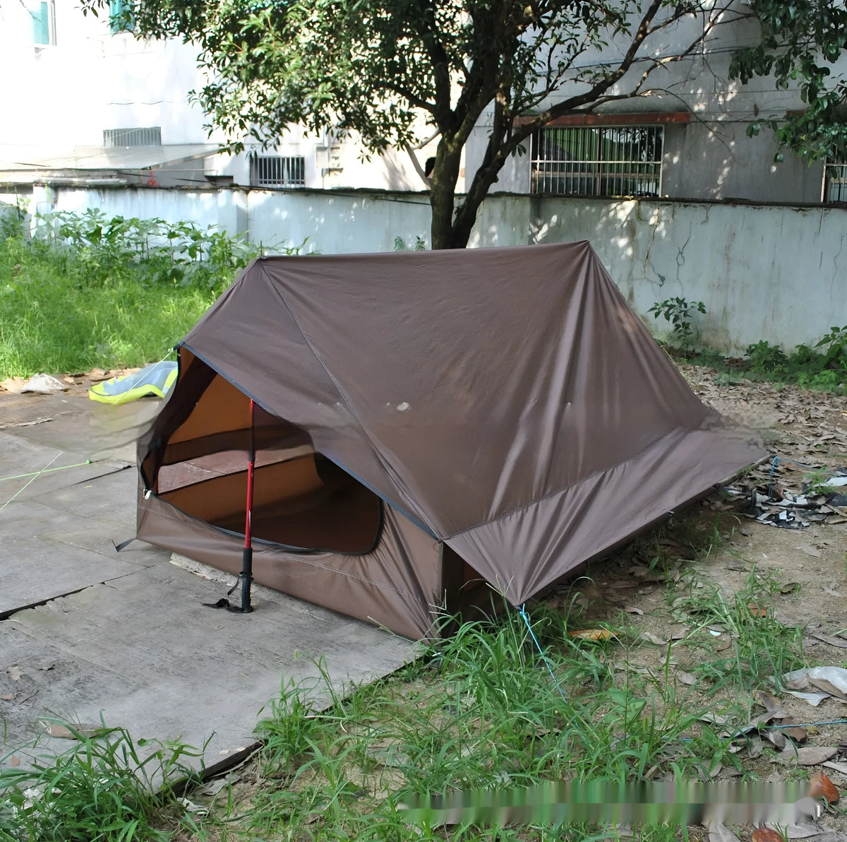 Brown A-line pole-free cabin tent pitched with hiking canes showing spacious interior dimensions