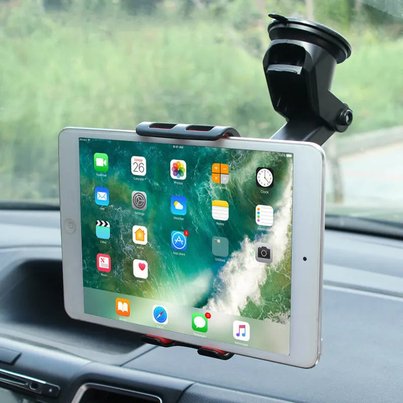 Black universal tablet PC car stand bracket clamped to dashboard centre console holding a tablet
