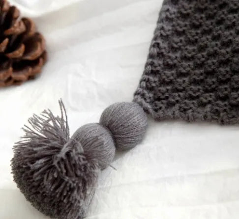 Nordic-style fringed knit ball acrylic blanket in beige colour, laid flat showing its 130x170cm size.