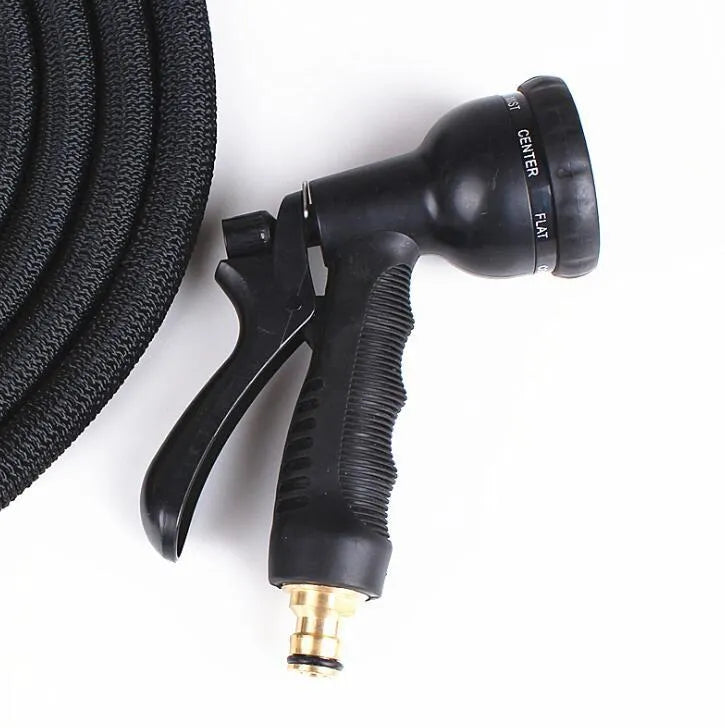 Expandable magic flexible water hose in black laid on grass showing compact initial length and stretched working length