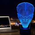 3D acrylic LED lamp displaying coloured light on a desk, with a remote control and USB cable