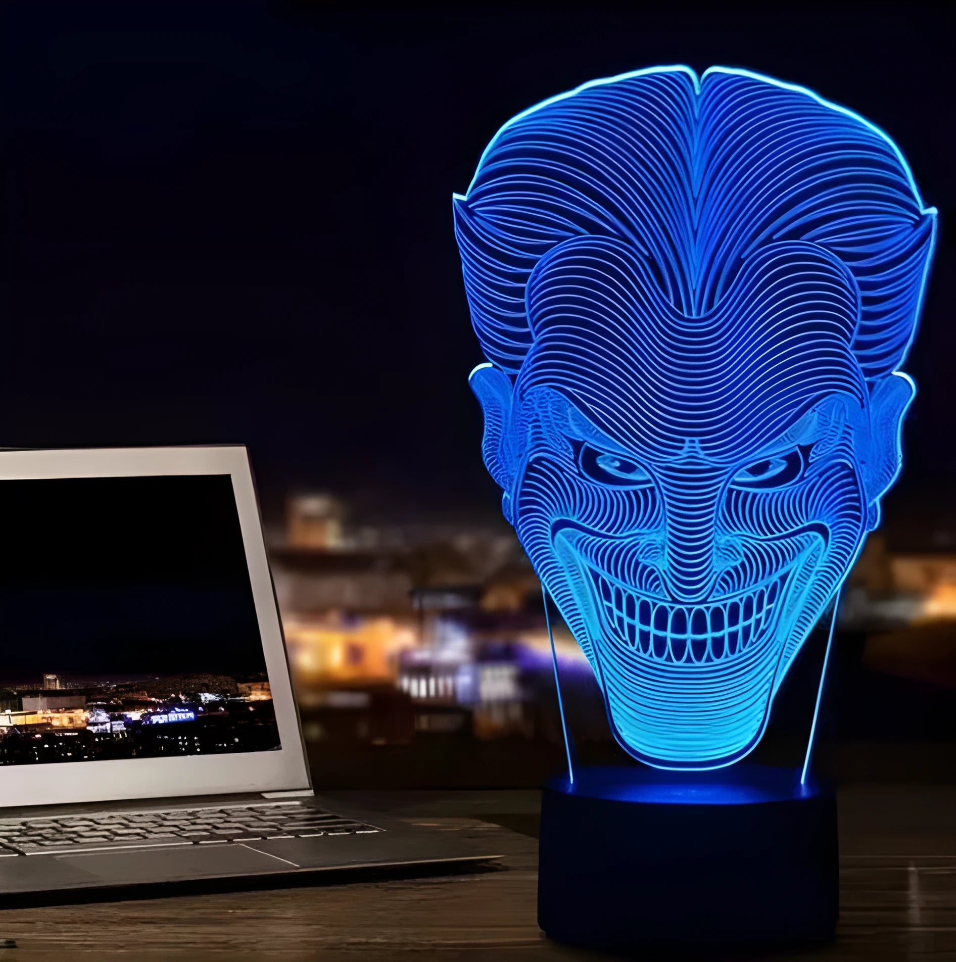 3D acrylic LED lamp displaying coloured light on a desk, with a remote control and USB cable