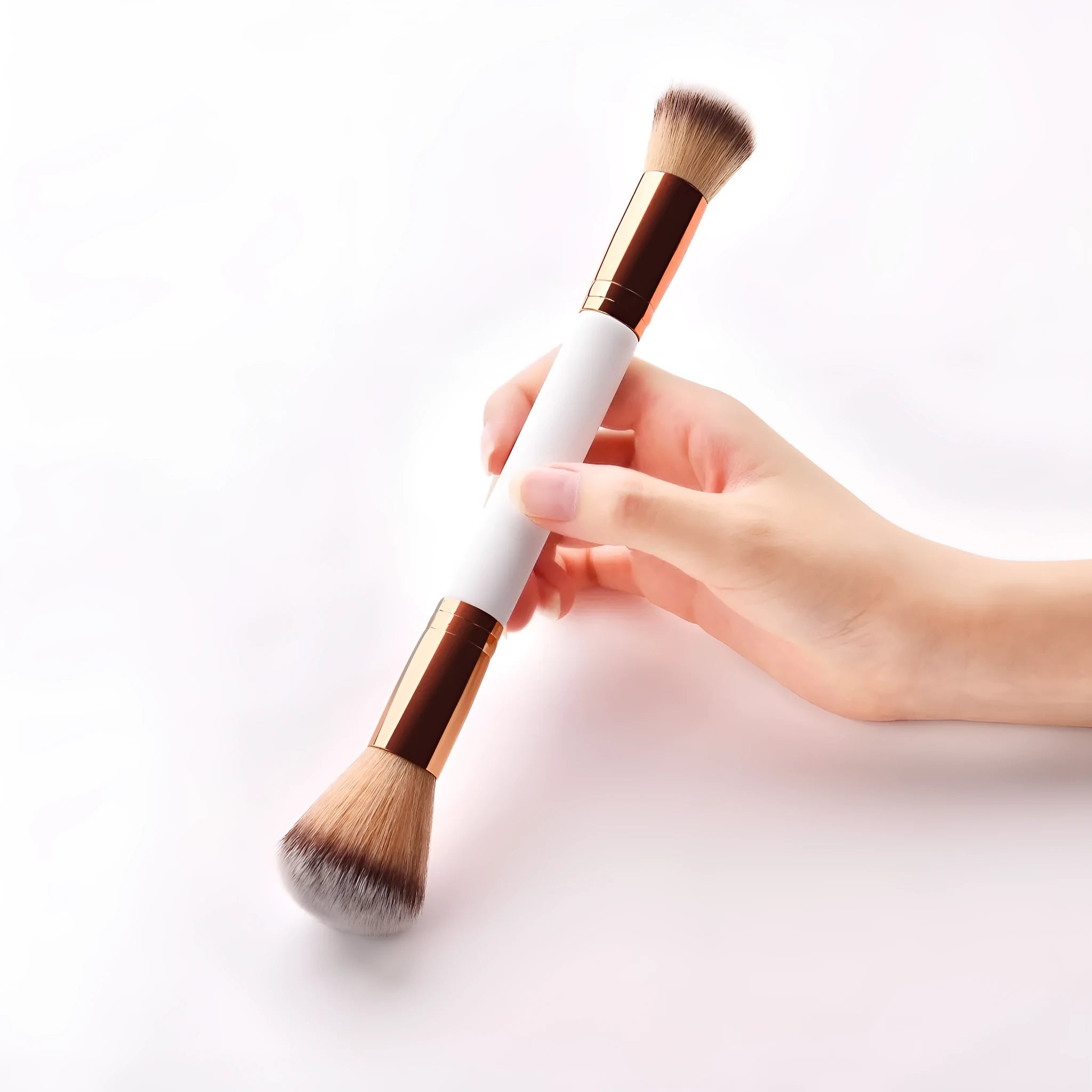 White double head makeup brush with wooden handle and nylon wool bristles on flat surface