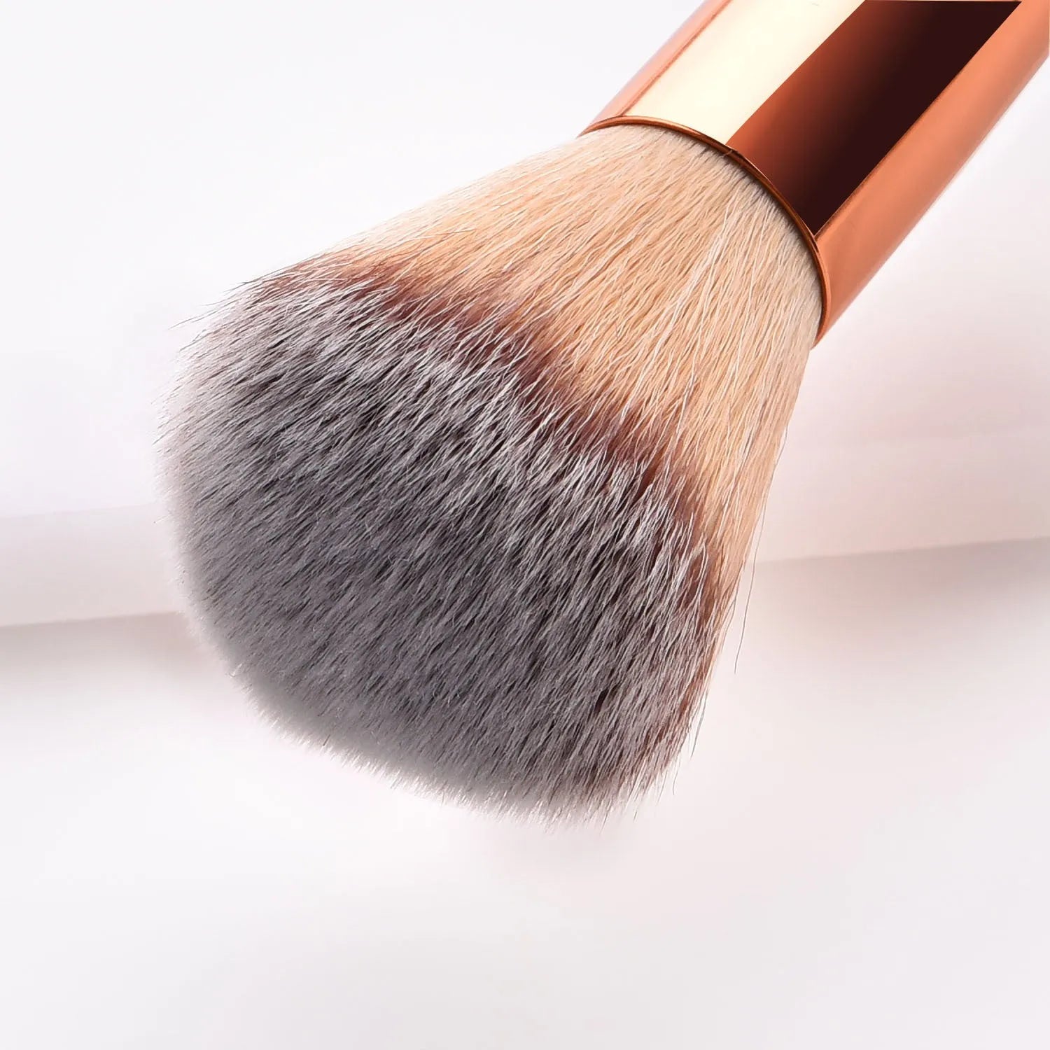 White double head makeup brush with wooden handle and nylon wool bristles on flat surface
