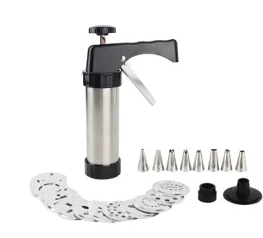 Stainless steel biscuit press gun with assorted cookie moulds and icing nozzles on a baking sheet.