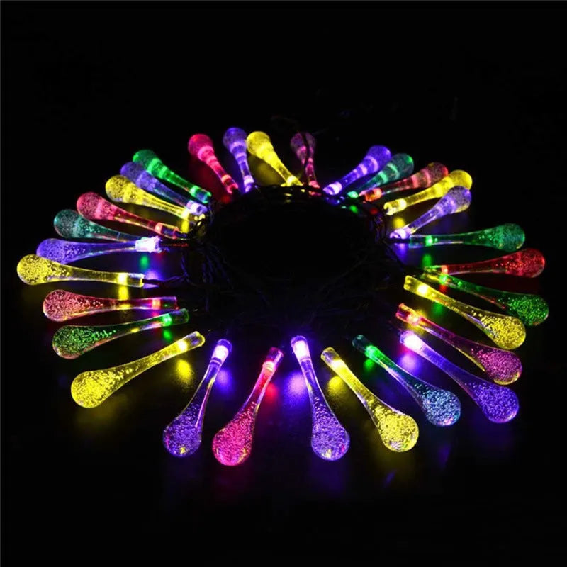 Solar-powered LED Water Drops string lights installed outdoors with 30 bulbs on a 6.5 metre waterproof cable