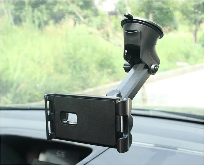 Black universal tablet PC car stand bracket clamped to dashboard centre console holding a tablet