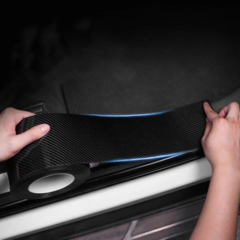 Black carbon fiber self-adhesive anti-collision decorative strip roll for car door threshold and bumper edge protection.