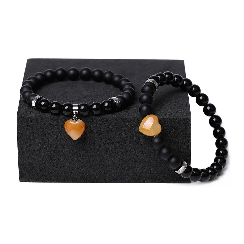 Matching natural stone couple bracelets with geometric heart shape in polished obsidian.