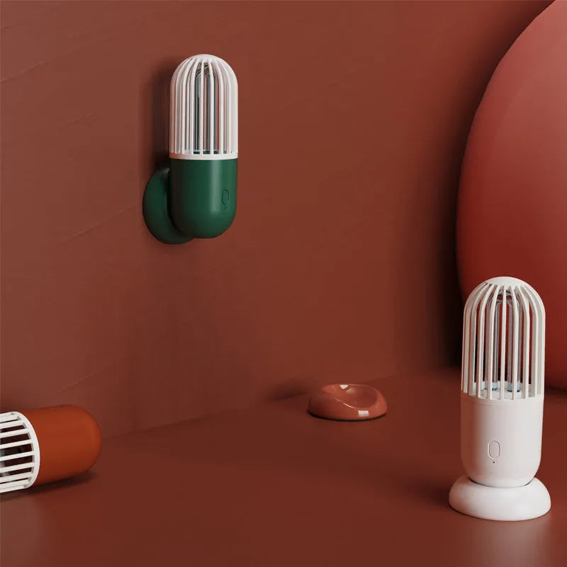 Portable capsule-shaped UVC disinfection lamp in black, showing compact size.