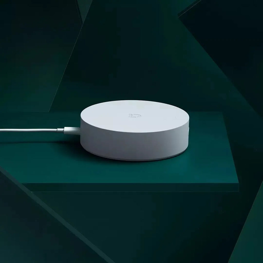 White circular smart home gateway with UK plug for wireless wall control
