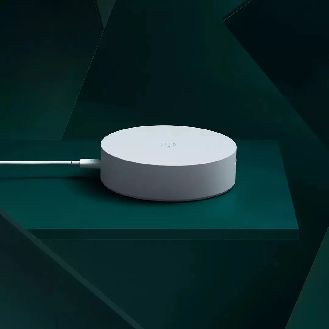 White circular smart home gateway with UK plug for wireless wall control