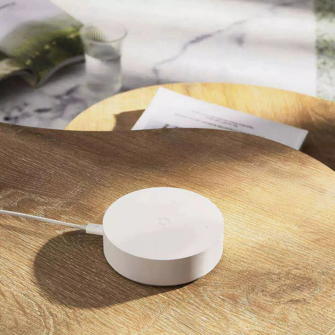 White circular smart home gateway with UK plug for wireless wall control