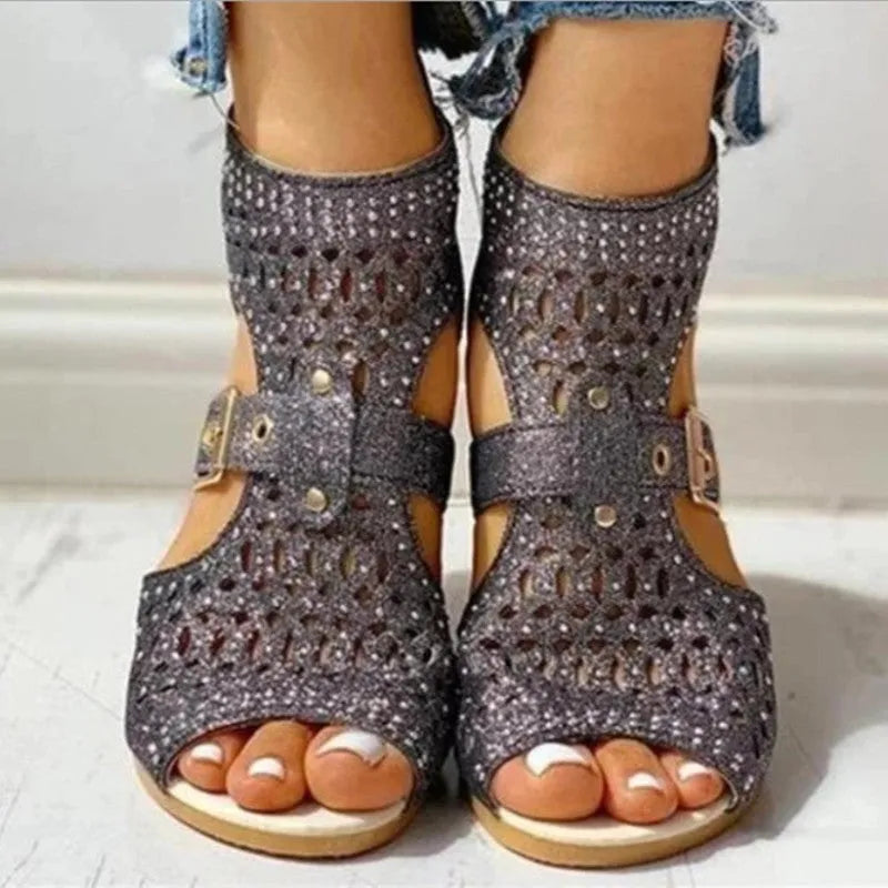 Women's beige rivet flat sandals showing fish mouth toe and back zipper closure on a wedge heel.
