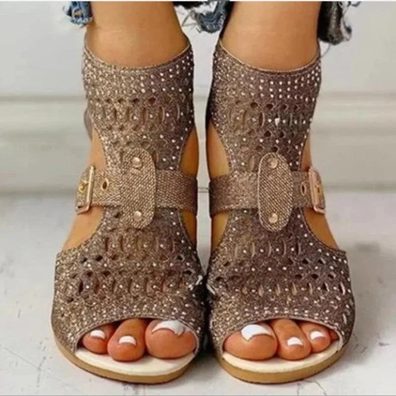 Women's beige rivet flat sandals showing fish mouth toe and back zipper closure on a wedge heel.