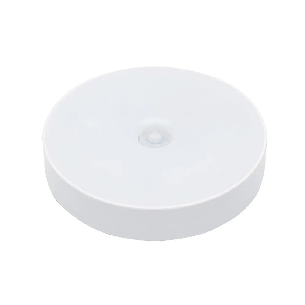 Small circular beige or white USB rechargeable body sensing LED night light with adhesive tape