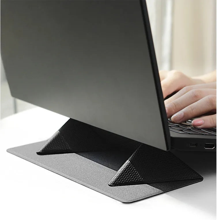 Blue foldable laptop cooling bracket with anti-slip surface shown open next to a closed laptop