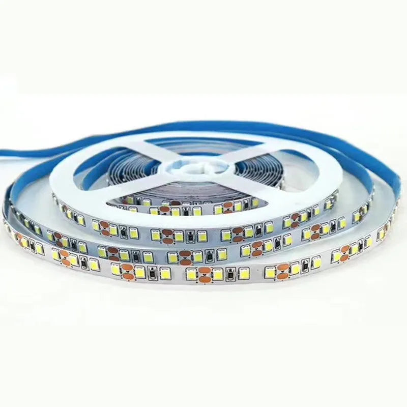 Close-up of a flexible 12V LED light strip with closely spaced white LEDs, shown on a retail shelf.