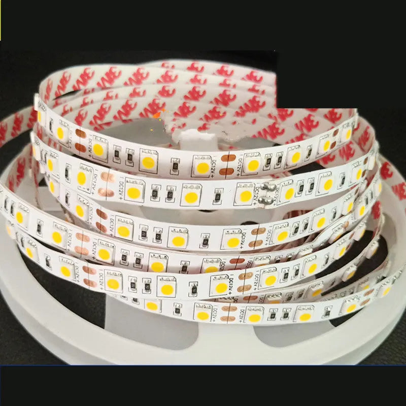 Close-up of a flexible 12V LED light strip with closely spaced white LEDs, shown on a retail shelf.