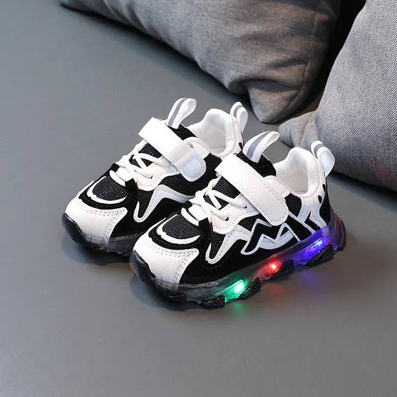 Kids black breathable mesh Velcro sneakers with a rubber sole, shown on a grey background.