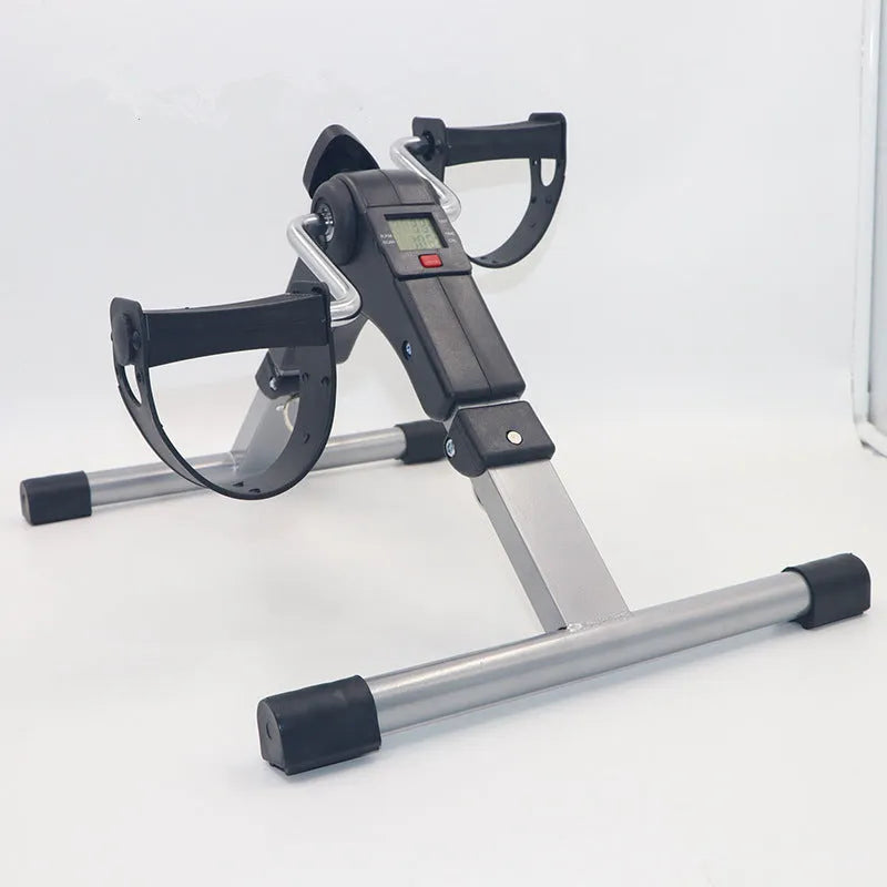 Black mini bike leg trainer with mechanical resistance, rubber and steel body, 36cm by 48cm by 23.3cm