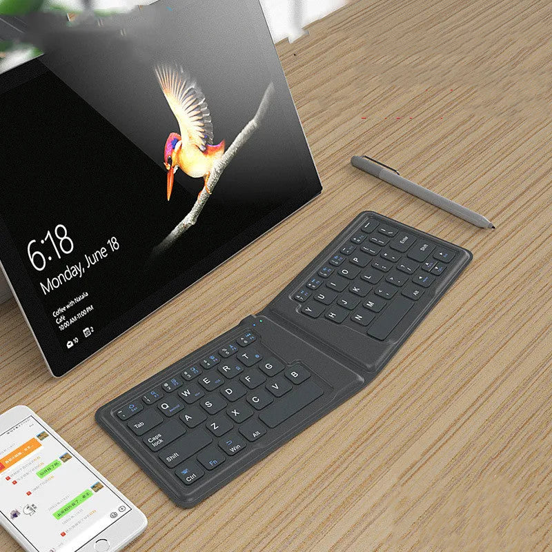 Folding Bluetooth keyboard in ABS with 64 keys, open on desk with iPad