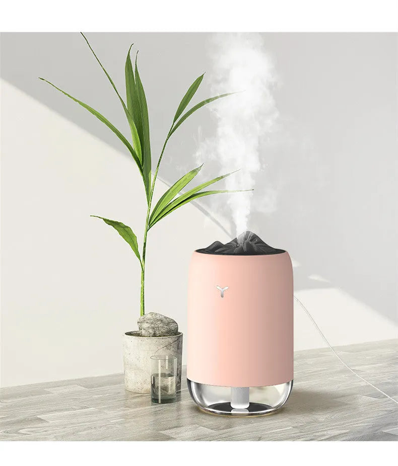 Magic Flame columnar ultrasonic humidifier in light blue colour on a desktop, showing mist output and USB cable.