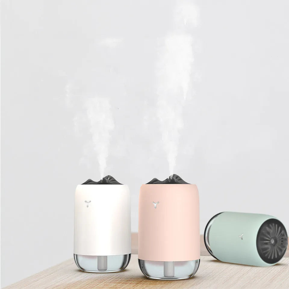 Magic Flame columnar ultrasonic humidifier in light blue colour on a desktop, showing mist output and USB cable.