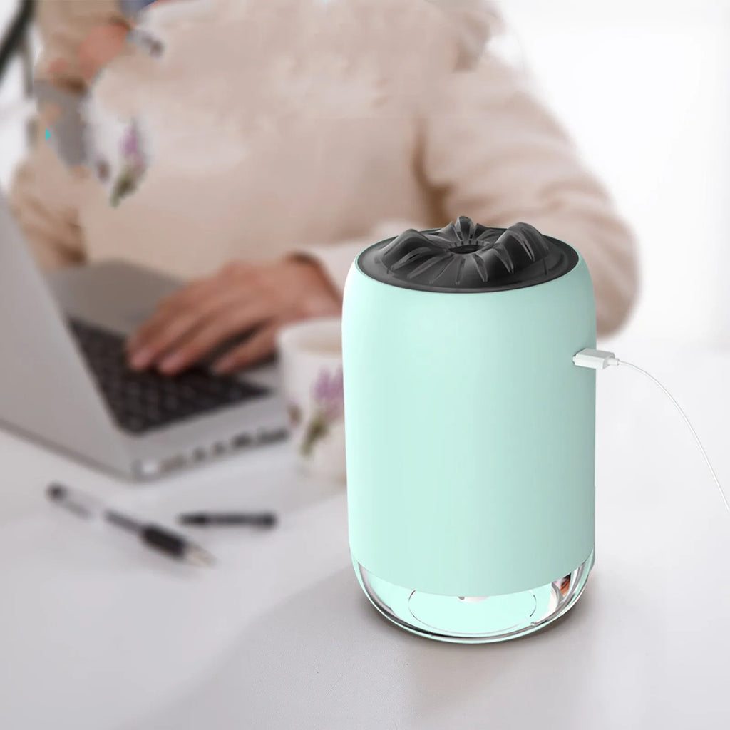 Magic Flame columnar ultrasonic humidifier in light blue colour on a desktop, showing mist output and USB cable.